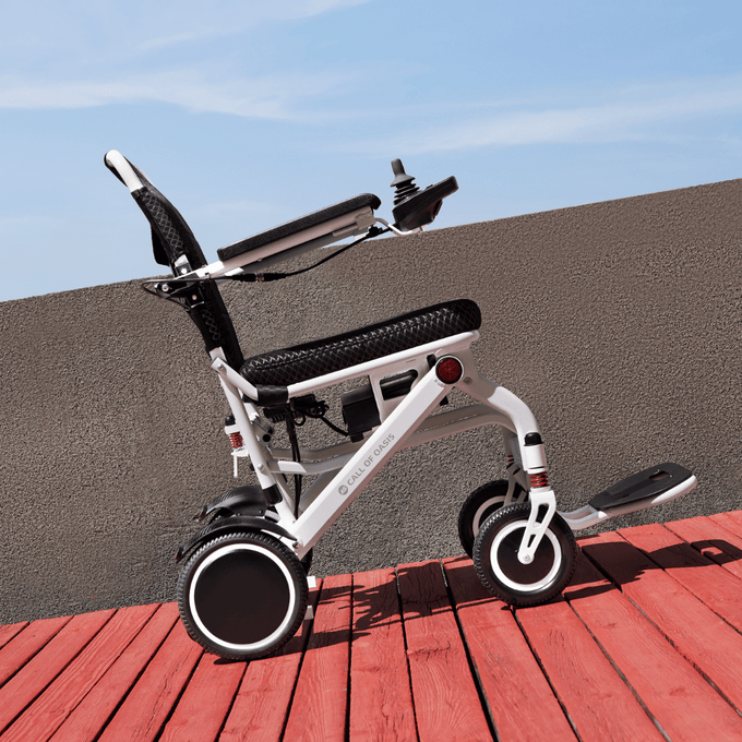 Heavy-duty electric wheelchair with large rear tires on a park path, lifestyle hero image
